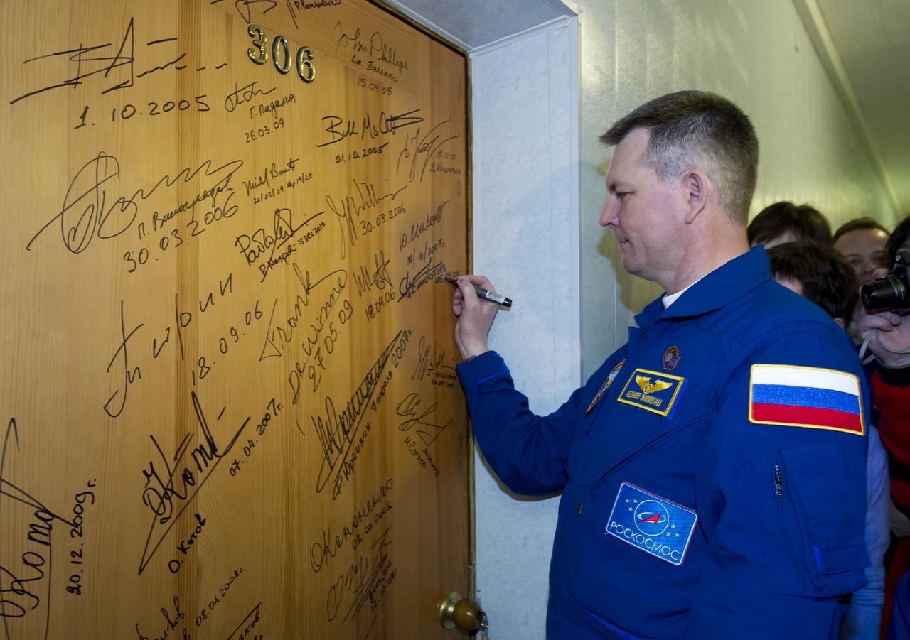 Expedition 27 Soyuz Commander Alexander Samokutyaev performs the traditional door signing Monday, April 4, 2011 at the Cosmonaut Hotel in Baikonur, Kazakhstan. Samokutyaev was launched onboard the Soyuz rocket the following morning with Expedition 27 NASA Flight Engineer Ron Garan and Russian Flight Engineer Andrey Borisenko on a mission to the International Space Station (ISS).  Photo Credit: (NASA/Carla Cioffi) 