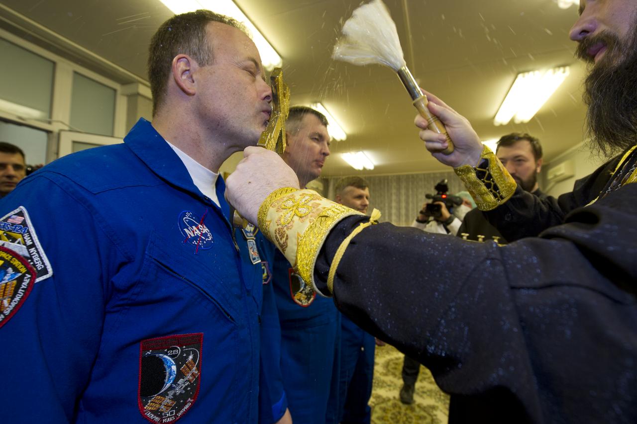 Expedition 27 Ron Garan, left, receives the traditional blessing from a Russian Orthodox priest at the Cosmonaut Hotel on the evening before his Soyuz launch to the International Space Station on Monday, April 4, 2011 in Baikonur, Kazakhstan.  Photo Credit: (NASA/Carla Cioffi) 