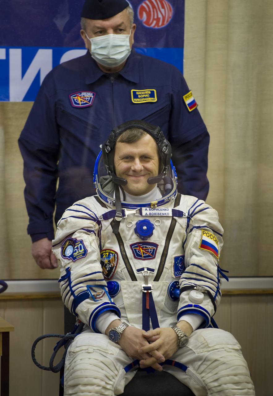 Expedition 27 Russian Flight Engineer Andrey Borisenko awaits to have his Russian Sokol suit prepared for launch by a technician at the Baikonur Cosmodrome in Baikonur, Kazakhstan, Tuesday, April 5, 2011. Photo Credit: (NASA/Carla Cioffi)