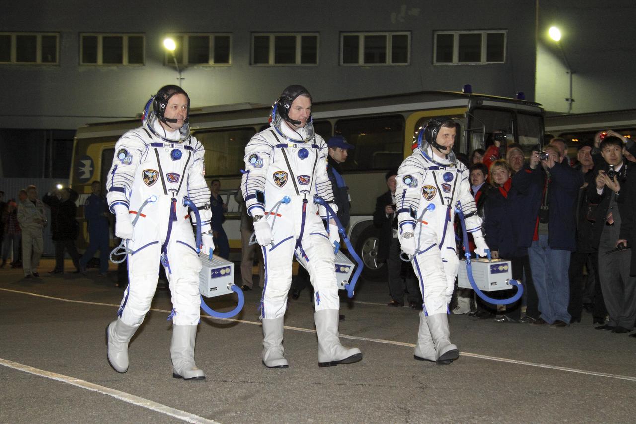 Expedition 27 NASA Flight Engineer Ron Garan, left, Expedition 27 Soyuz Commander Alexander Samokutyaev and Expedition 27 Flight Engineer Andrey Borisenko, third from left, walk out to salute Head of the Russian Federal Space Agency Anatoly Perminov at the Baikonur Cosmodrome prior to their launch onboard the Soyuz TMA-21 to the International Space Station (ISS), Tuesday, April 5, 2011 in Kazakhstan.  Photo Credit: (NASA/Victor Zelentsov)