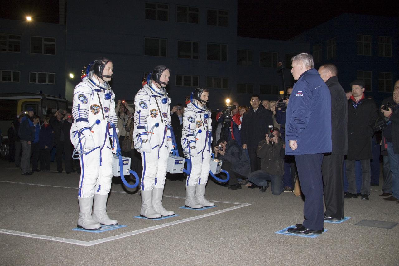 Expedition 27 NASA Flight Engineer Ron Garan, left, Expedition 27 Soyuz Commander Alexander Samokutyaev and Expedition 27 Flight Engineer Andrey Borisenko, third from left, walk out to salute Head of the Russian Federal Space Agency Anatoly Perminov, far right, at the Baikonur Cosmodrome prior to their launch onboard the Soyuz TMA-21 to the International Space Station (ISS), Tuesday, April 5, 2011 in Kazakhstan.  Photo Credit: (NASA/Victor Zelentsov)