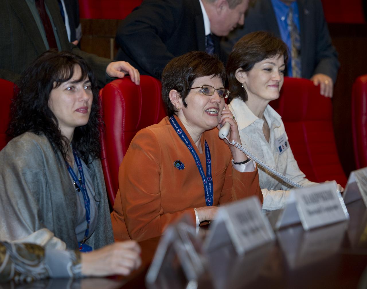 Zoya Borisenko, center, wife of Expedition 27 Flight Engineer Andrey Borisenko, is seen at Russian Mission Control in Korolev, Russia speaking to her husband shortly after his arrival at the International Space Station on Thursday, April 7, 2011. Photo Credit: (NASA/Carla Cioffi)