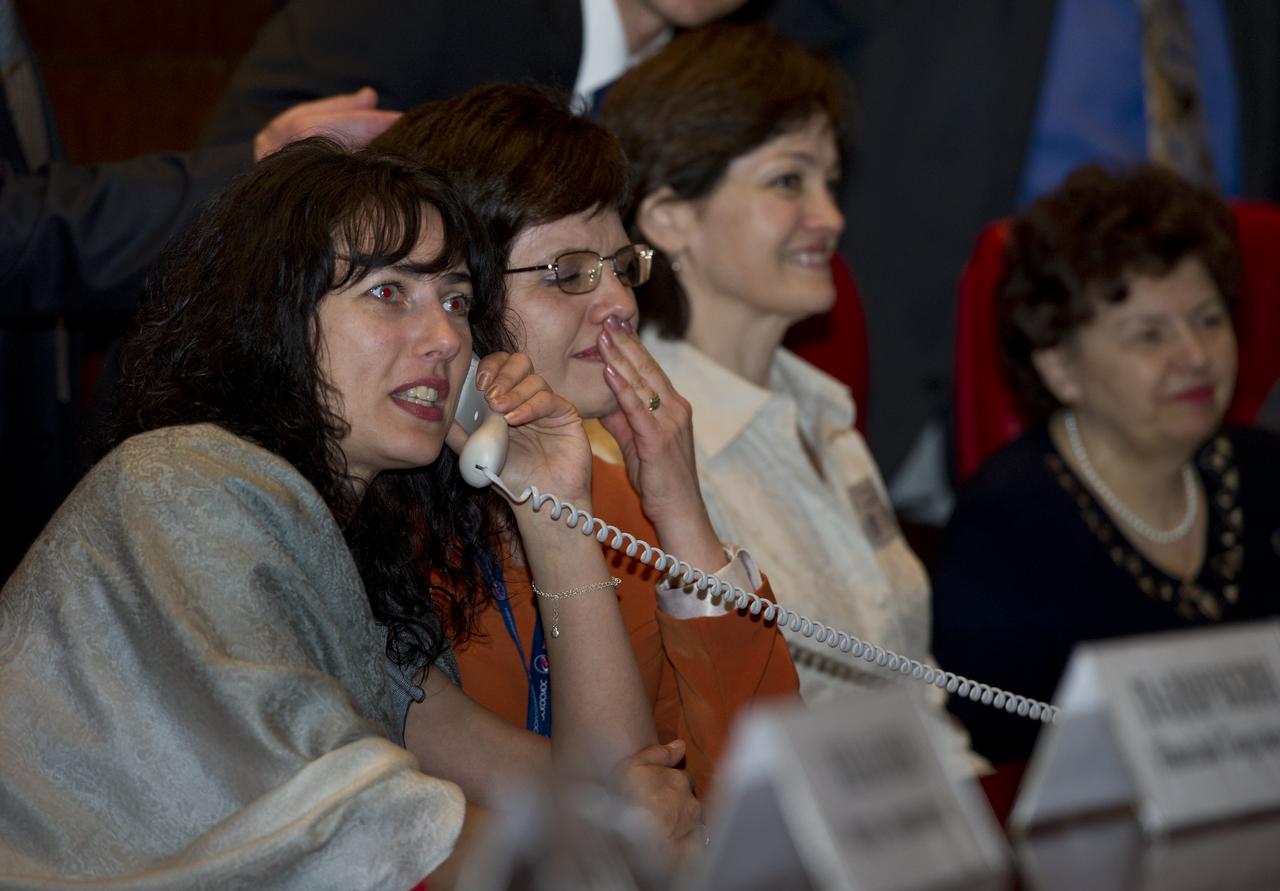 Oksana Samokutyaev, far left, wife of Expedition 27 Soyuz Commander Alexander Samokutyaev, is seen at Russian Mission Control in Korolev, Russia speaking to her husband shortly after his arrival at the International Space Station on Thursday, April 7, 2011. Photo Credit: (NASA/Carla Cioffi)