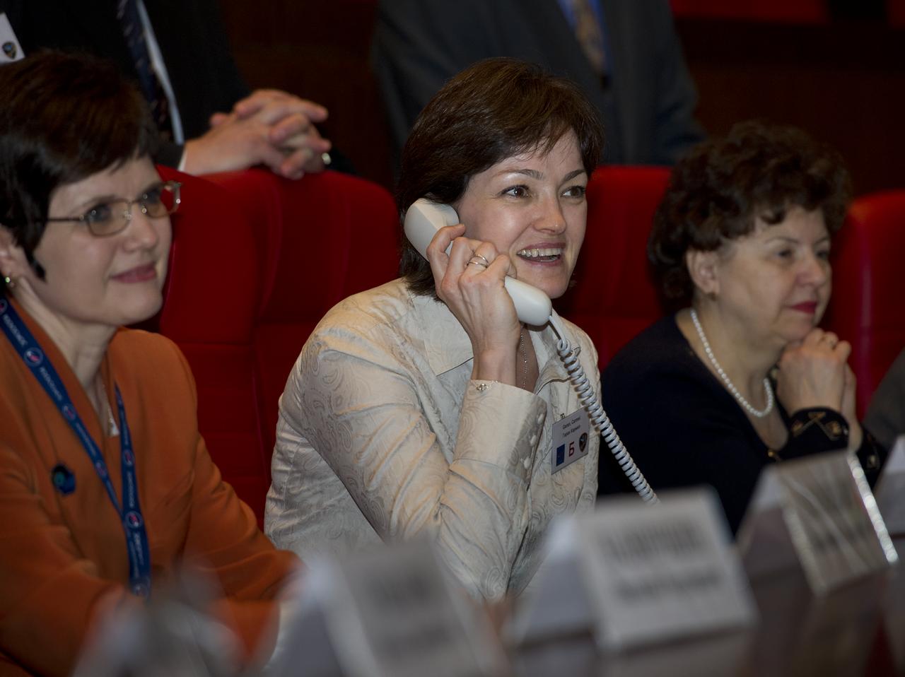Carmel Garan, center, wife of Expedition 27 NASA Flight Engineer Ron Garan, is seen at Russian Mission Control in Korolev, Russia speaking to her husband shortly after his arrival at the International Space Station on Thursday, April 7, 2011. Photo Credit: (NASA/Carla Cioffi)
