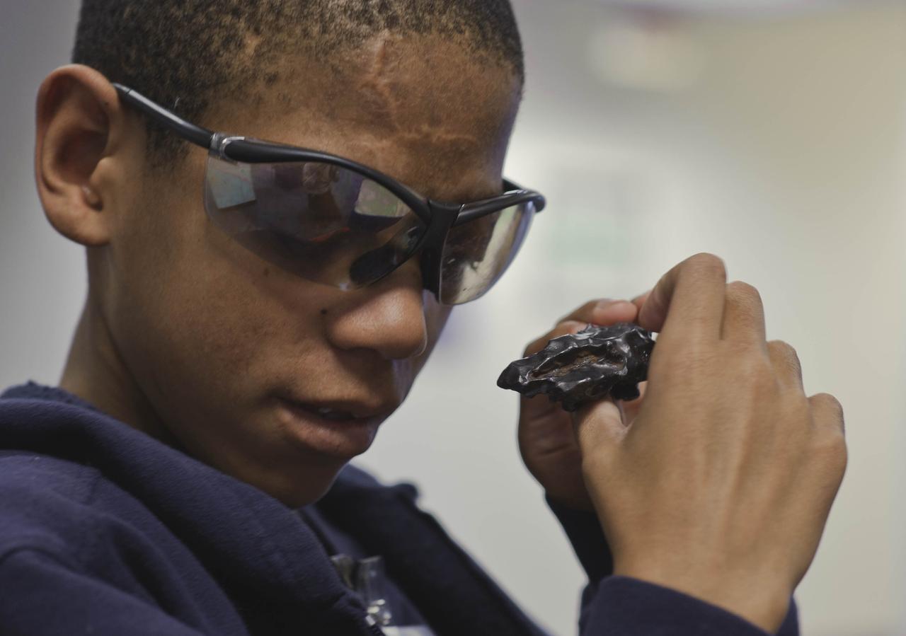 A student from the Maryland School For the Blind explores an object while learning about Meteorites, Asteroids and Comets during NASA's Disability Mentoring Day, Thursday, April 7, 2011, at NASA Headquarters in Washignton. Photo Credit: (NASA/Paul E. Alers)
