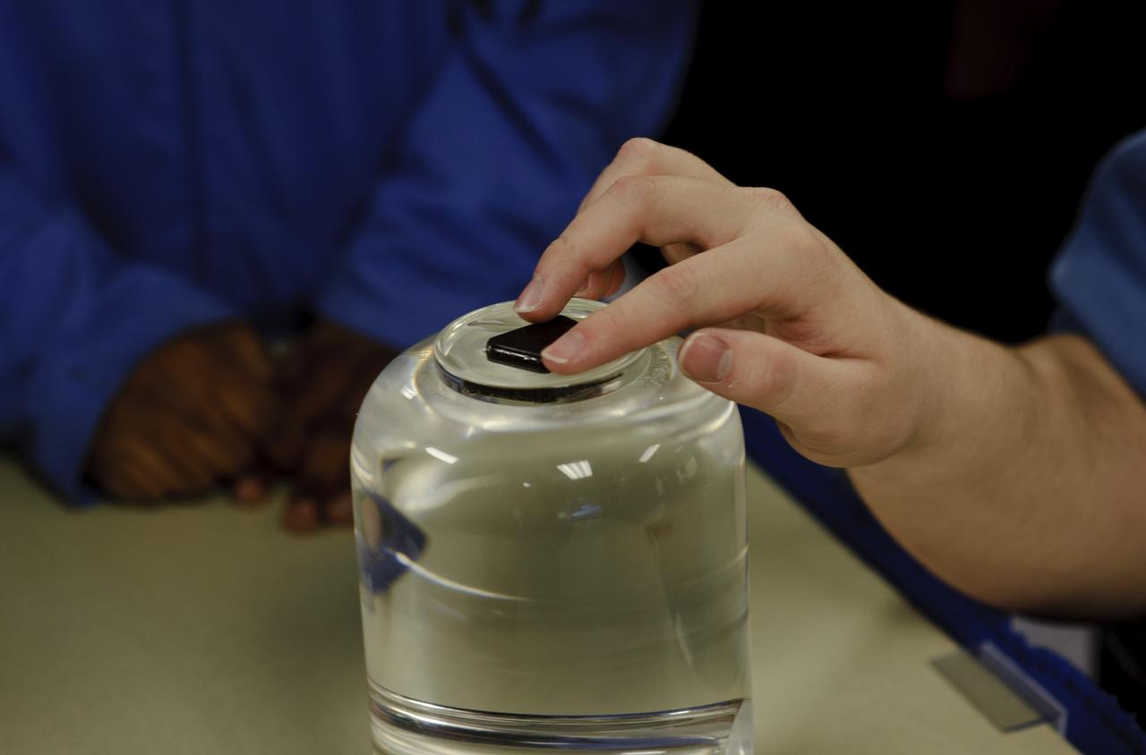 A student from the Maryland School For the Blind touches a piece of moon rock while learning about Meteorites, Asteroids and Comets during NASA's Disability Mentoring Day, Thursday, April 7, 2011, at NASA Headquarters in Washignton. Photo Credit: (NASA/Paul E. Alers)