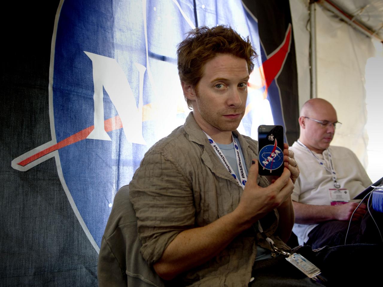 Actor Seth Green, a NASA Twitter follower, holds up his mobile device bearing the NASA emblem during the STS-134 Tweetup, Thursday, April 28, 2011, at Kennedy Space Center in Cape Canaveral, Fla. About 150 NASA Twitter followers attended the event. Photo Credit: (NASA/Paul E. Alers)