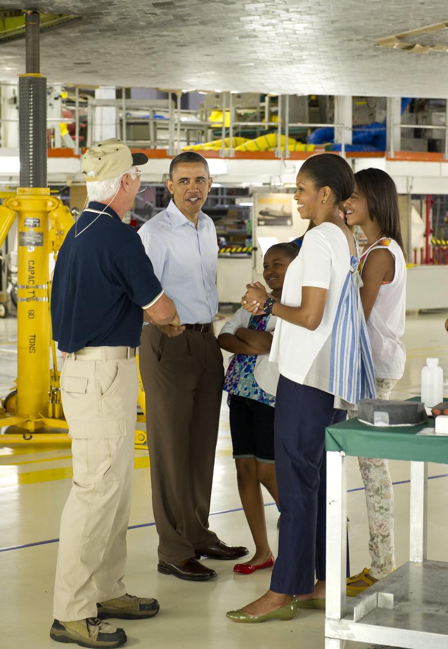 Terry White, United Space Alliance project lead for thermal protection systems, left, sakes hands with President Barack Obama after showing his family, Sasha, First Lady Michelle Obama, Malia, and Marian Robinson, how tiles work on the space shuttle during their visit to the Orbital Processing Facility at the NASA Kennedy Space Center in Cape Canaveral, Fla., Friday, April 29, 2011. Photo Credit: (NASA/Bill Ingalls)