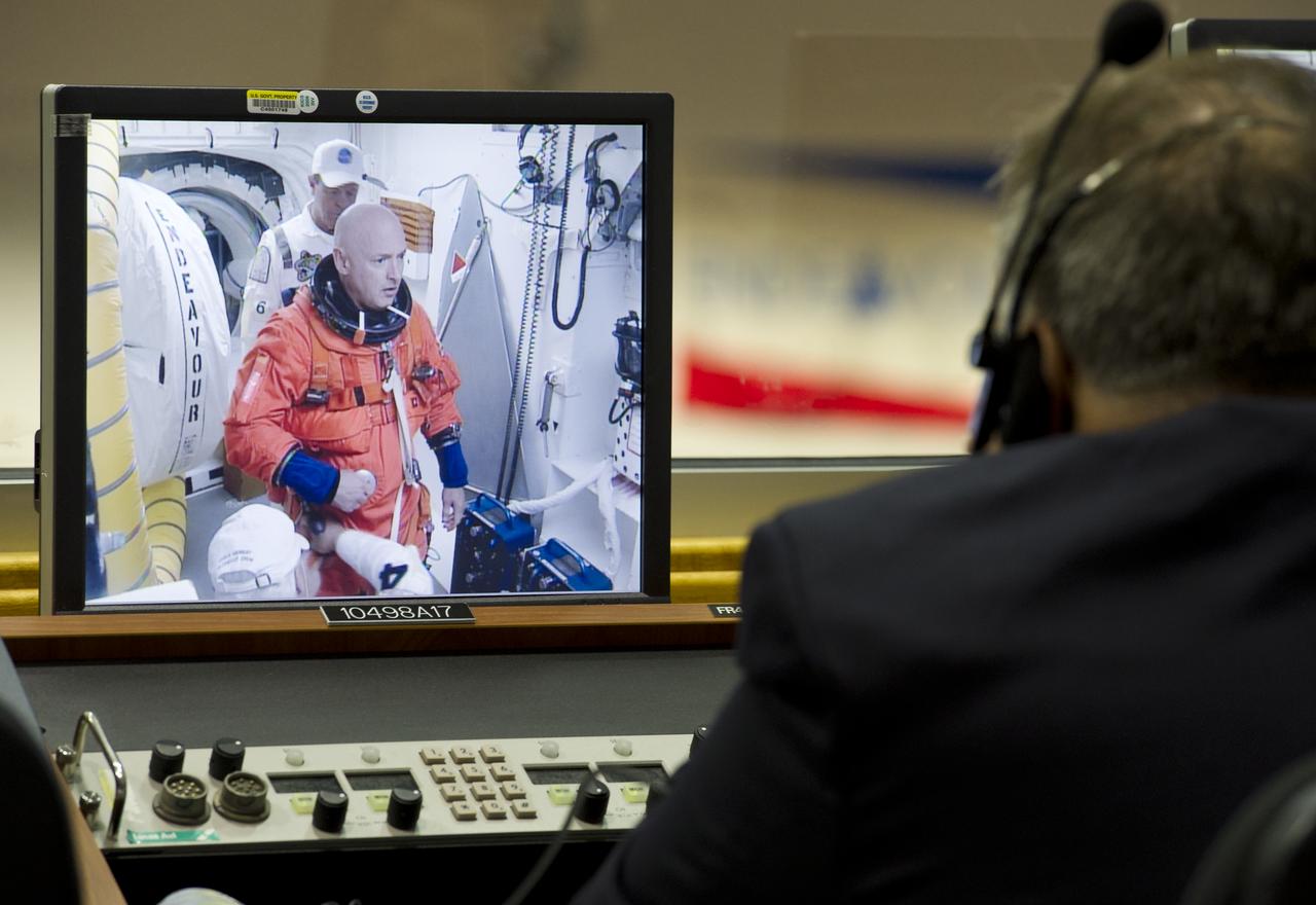 STS-134 mission Commander Mark Kelly is seen preparing to enter space shuttle Endeavour on a monitor in Firing Room Four of the Launch Control Center (LCC), Monday,  May 16, 2011, at the Kennedy Space Center in Cape Canaveral, Fla.  During the mission, Endeavour and the STS-134 crew will deliver the Alpha Magnetic Spectrometer (AMS) and spare parts including two S-band communications antennas, a high-pressure gas tank and additional spare parts for Dextre. Photo Credit: (NASA/Bill Ingalls)