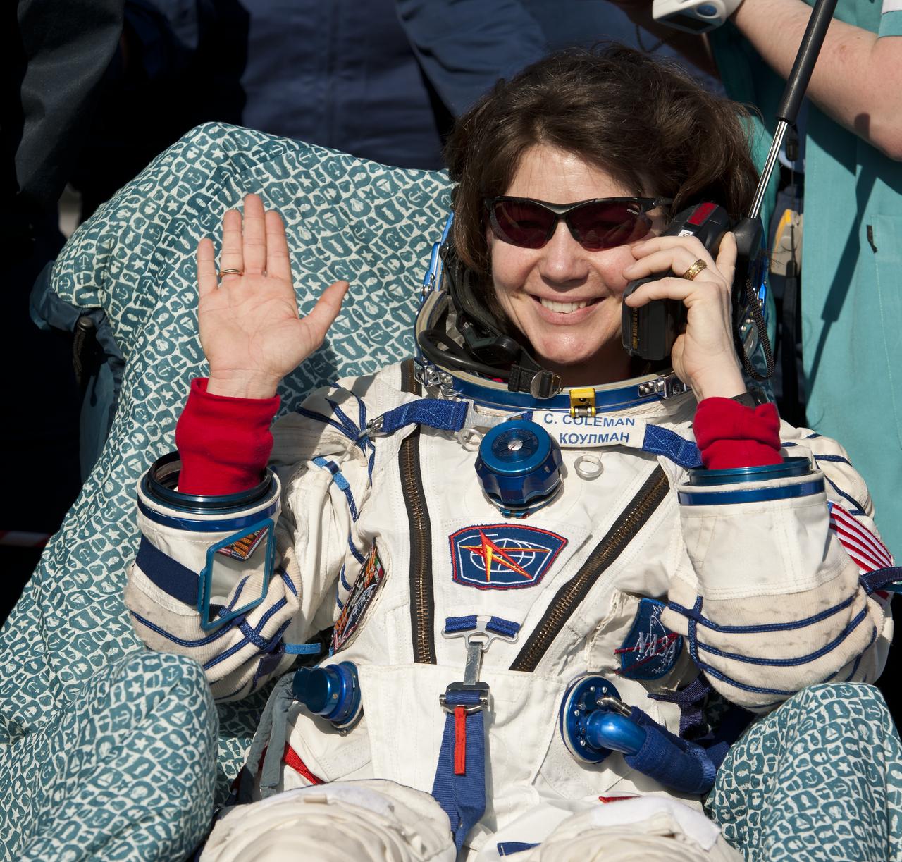 Expedition 27 Flight Engineer Cady Coleman waves hello and talks on a satellite phone to her family shortly after she and Commander Dmitry Kondratyev and Flight Engineer Paolo Nespoli landed in their Soyuz TMA-20 southeast of the town of Zhezkazgan, Kazakhstan, on Tuesday, May 24, 2011.  NASA Astronaut Coleman, Russian Cosmonaut Kondratyev and Italian Astronaut Nespoli are returning from more than five months onboard the International Space Station where they served as members of the Expedition 26 and 27 crews. Photo Credit: (NASA/Bill Ingalls)