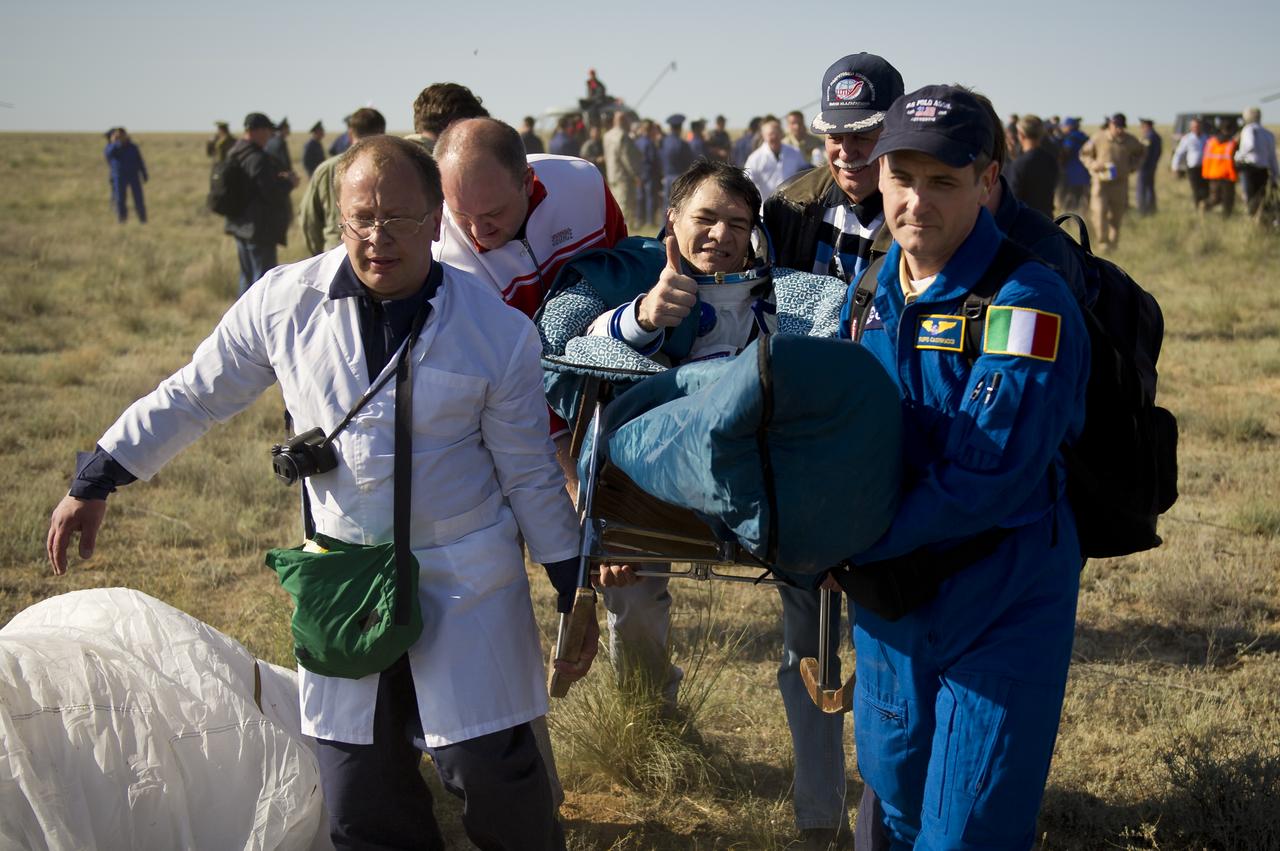 Expedition 27 Flight Engineer Paolo Nespoli gives a thumbs up as he is carried in a chair to the medical tent shortly after he and Commander Dmitry Kondratyev and Flight Engineer Cady Coleman landed in their Soyuz TMA-20 southeast of the town of Zhezkazgan, Kazakhstan, on Tuesday, May 24, 2011. NASA Astronaut Coleman, Russian Cosmonaut Kondratyev and Italian Astronaut Nespoli are returning from more than five months onboard the International Space Station where they served as members of the Expedition 26 and 27 crews. Photo Credit: (NASA/Bill Ingalls)
