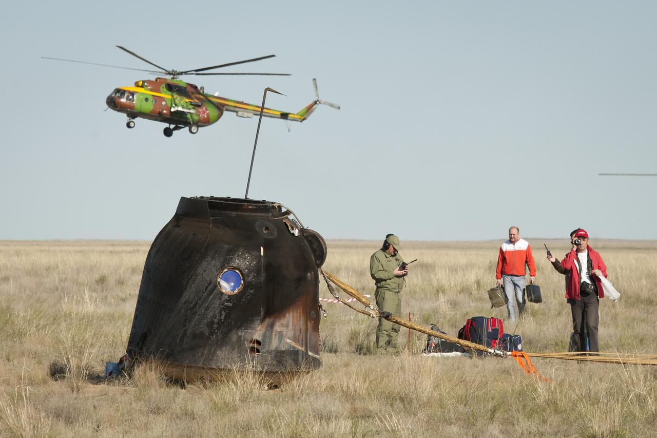 Russian Search and Rescue and other recovery teams begin to gather around the Soyuz TMA-20 spacecraft immediately after it landed with Expedition 27 Commander Dmitry Kondratyev and Flight Engineers Paolo Nespoli and Cady Coleman onboard in a remote area southeast of the town of Zhezkazgan, Kazakhstan, on Tuesday, May 24, 2011. NASA Astronaut Coleman, Russian Cosmonaut Kondratyev and Italian Astronaut Nespoli are returning from more than five months onboard the International Space Station where they served as members of the Expedition 26 and 27 crews. Photo Credit: (NASA/Bill Ingalls)