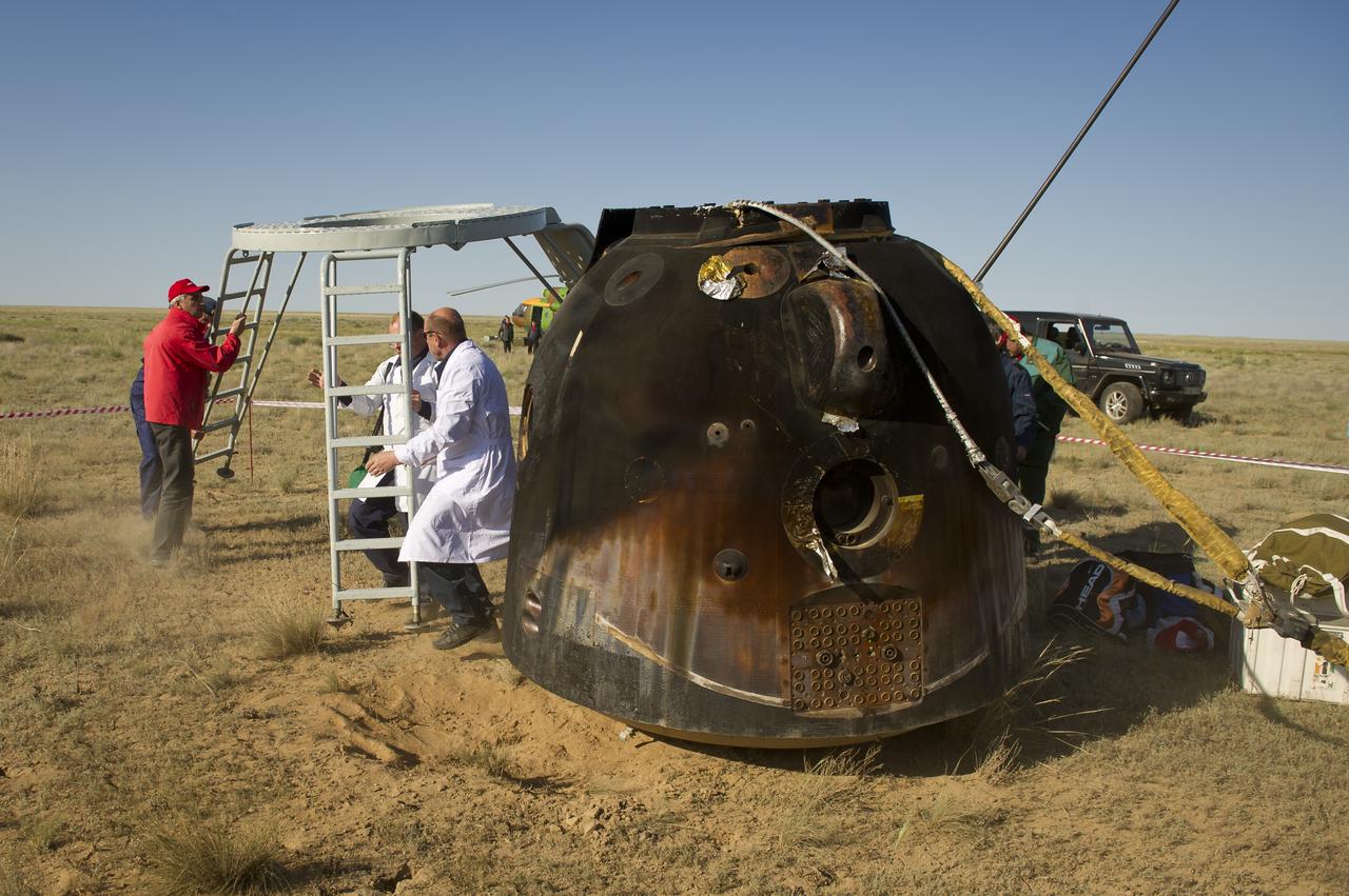 Recovery teams move a work stand around the Soyuz TMA-20 spacecraft immediately after it landed with Expedition 27 Commander Dmitry Kondratyev and Flight Engineers Paolo Nespoli and Cady Coleman onboard in a remote area southeast of the town of Zhezkazgan, Kazakhstan, on Tuesday, May 24, 2011. NASA Astronaut Coleman, Russian Cosmonaut Kondratyev and Italian Astronaut Nespoli are returning from more than five months onboard the International Space Station where they served as members of the Expedition 26 and 27 crews. Photo Credit: (NASA/Bill Ingalls)
