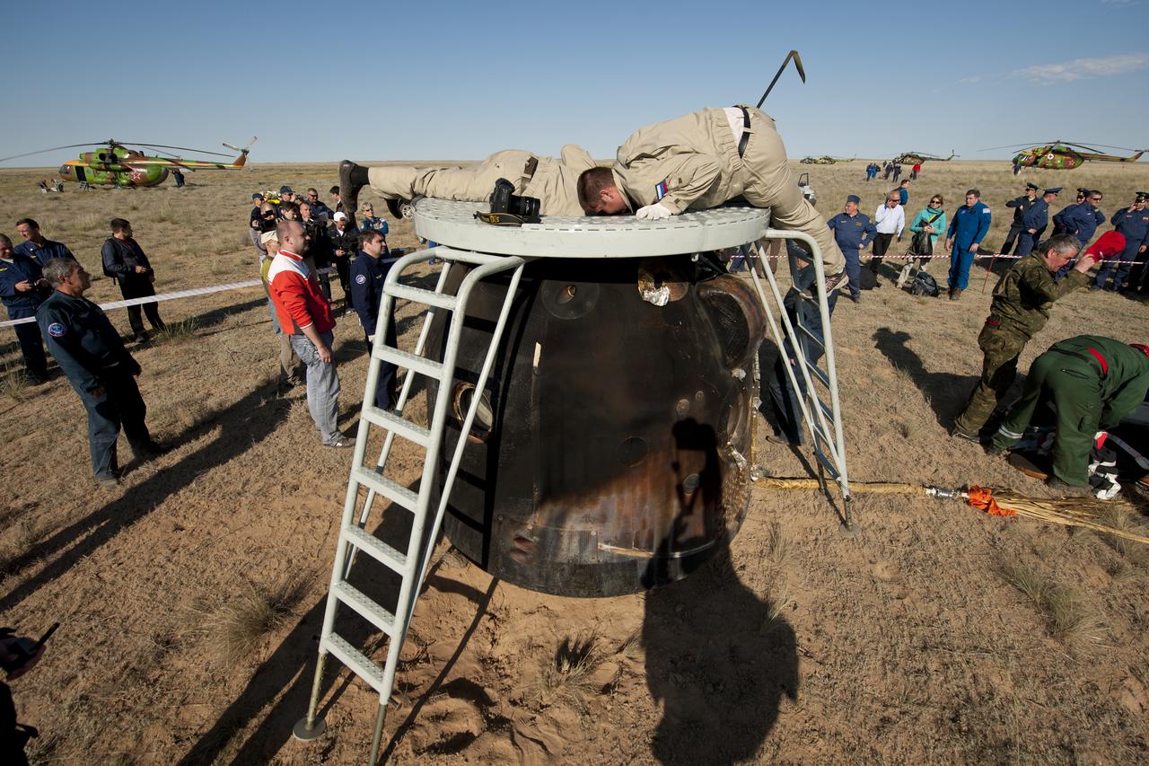 Russian support personnel work to help get crew members out of the Soyuz TMA-20 spacecraft shortly after the capsule landed with Expedition 27 Commander Dmitry Kondratyev and Flight Engineers Paolo Nespoli and Cady Coleman in a remote area southeast of the town of Zhezkazgan, Kazakhstan, on Tuesday, May 24, 2011. NASA Astronaut Coleman, Russian Cosmonaut Kondratyev and Italian Astronaut Nespoli are returning from more than five months onboard the International Space Station where they served as members of the Expedition 26 and 27 crews. Photo Credit: (NASA/Bill Ingalls)