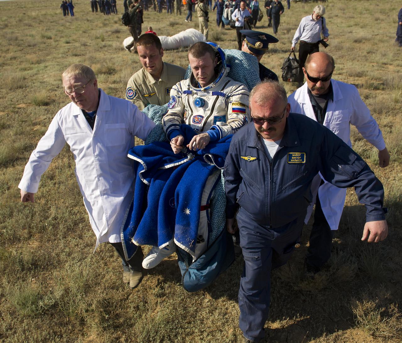 Expedition 27 Commander Dmitry Kondratyev is carried in a chair to the medical tent shortly after he and Flight Engineer Paolo Nespoli and Flight Engineer Cady Coleman landed in their Soyuz TMA-20 southeast of the town of Zhezkazgan, Kazakhstan, on Tuesday, May 24, 2011. NASA Astronaut Coleman, Russian Cosmonaut Kondratyev and Italian Astronaut Nespoli are returning from more than five months onboard the International Space Station where they served as members of the Expedition 26 and 27 crews. Photo Credit: (NASA/Bill Ingalls)