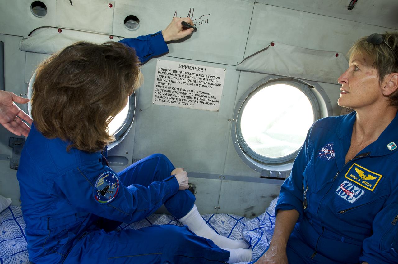 Expedition 27 Flight Engineer Cady Coleman signs the inside of her helicopter as NASA Chief of the Astronaut Office, Peggy Whitson looks on shortly after Coleman and Commander Dmitry Kondratyev and Flight Engineer Paolo Nespoli landed in their Soyuz TMA-20 southeast of the town of Zhezkazgan, Kazakhstan, on Tuesday, May 24, 2011. NASA Astronaut Coleman, Russian Cosmonaut Kondratyev and Italian Astronaut Nespoli are returning from more than five months onboard the International Space Station where they served as members of the Expedition 26 and 27 crews. Photo Credit: (NASA/Bill Ingalls)