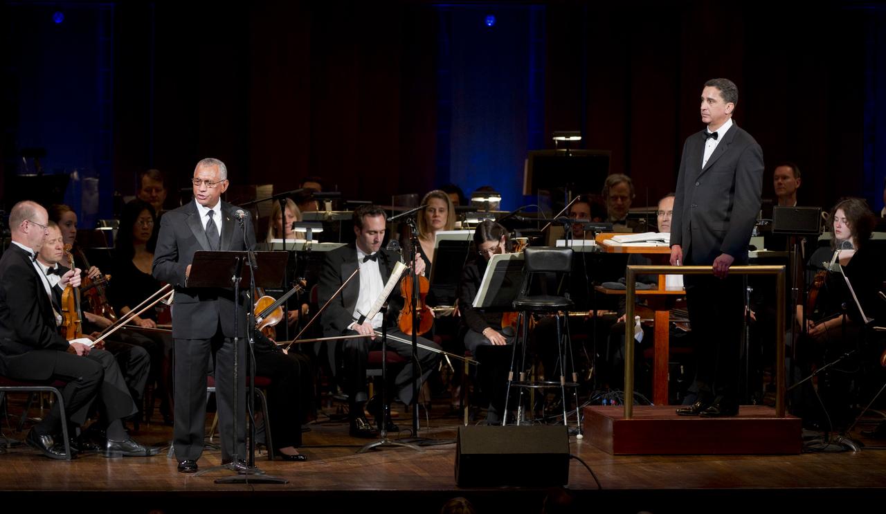 NASA Administrator Charles Bolden delivers opening remarks at the beginning of a program entitled Human Spaceflight: The Kennedy Legacy as Emil de Cou, conductor of the Space Philharmonic, right, looks on, Wednesday, May 25, 2011, in the concert hall at the John F. Kennedy Center for the Performing Arts in Washington. The event marked the 50th Anniversary of President John F. Kennedy's Special Message to the Congress on Urgent National Needs in which he stated "landing a man on the moon and returning him safely to earth". Photo Credit: (NASA/Paul E. Alers)