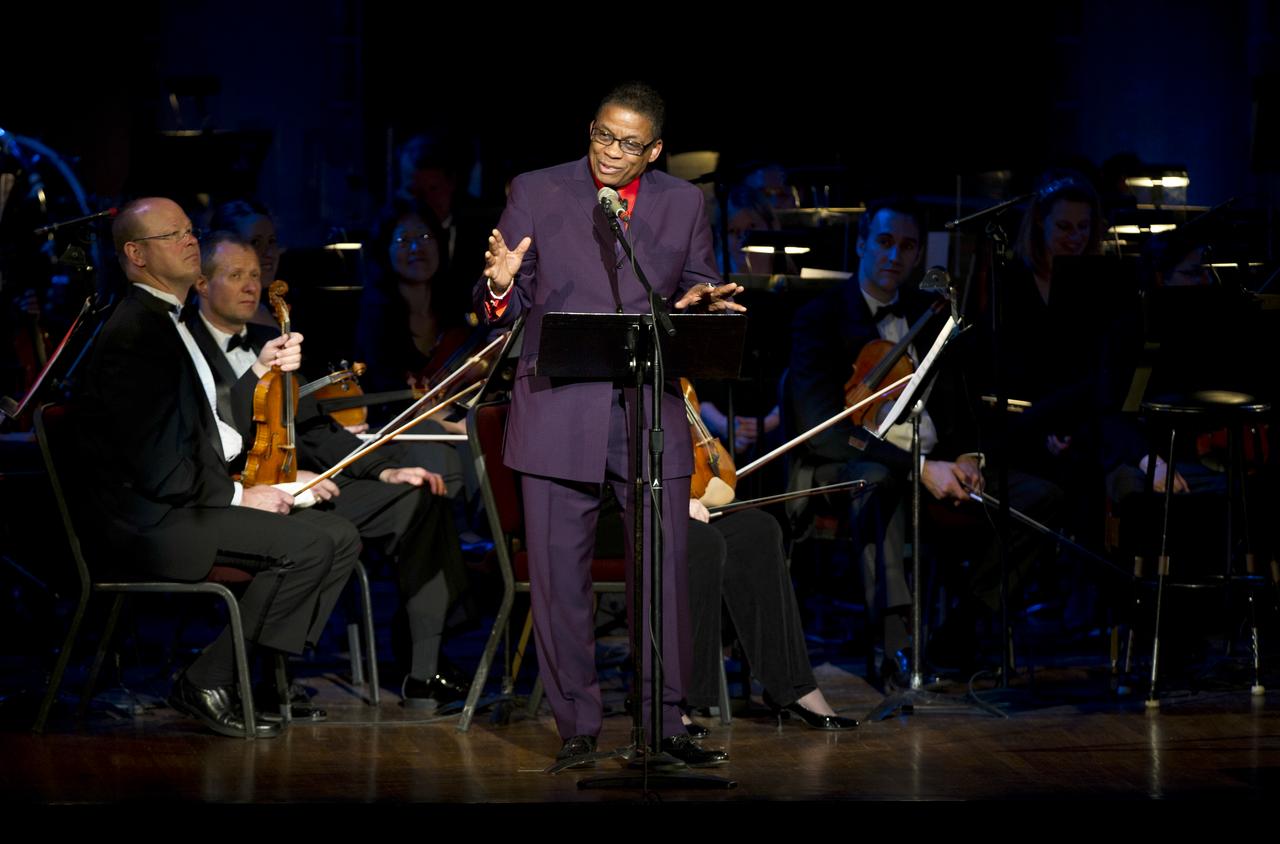 Musician Herbie Hancock delivers remarks as members of the Space Philharmonic look on during a program commemorating Human Spaceflight and the Kennedy Legacy, Wednesday, May 25, 2011, in the concert hall at the John F. Kennedy Center for the Performing Arts in Washington. The event marked the 50th Anniversary of President John F. Kennedy's Special Message to the Congress on Urgent National Needs in which he stated "landing a man on the moon and returning him safely to earth". Photo Credit: (NASA/Paul E. Alers)