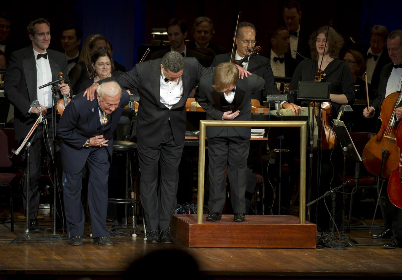Former Apolo 11 astronaut Buzz Aldrin, left, Emil de Cou, and Ted Kennedy III, right, bow at the end of a program commemorating Human Spaceflight and the Kennedy Legacy, Wednesday, May 25, 2011, in the concert hall at the John F. Kennedy Center for the Performing Arts in Washington. The event marked the 50th Anniversary of President John F. Kennedy's Special Message to the Congress on Urgent National Needs in which he stated "landing a man on the moon and returning him safely to earth". Photo Credit: (NASA/Paul E. Alers)