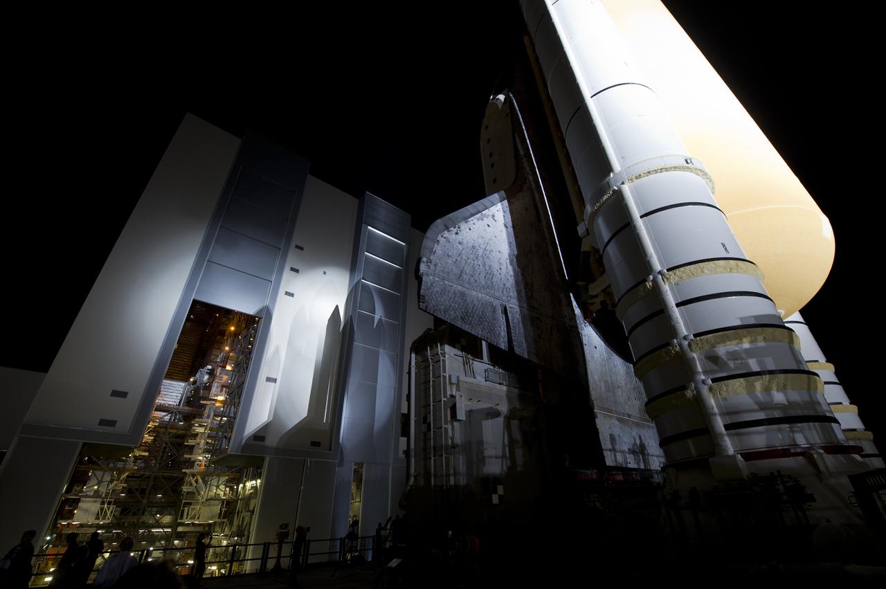 Space Shuttle Atlantis (STS-135) is seen atop the Mobile Launch Platform (MLP) as it begins its journey from High Bay 3 in the Vehicle Assembly Building to Launch Pad 39a for its final flight, Tuesday evening, May 31, 2011, at Kennedy Space Center in Cape Canaveral, Fla. The 3.4-mile trek, known as "rollout," will take about seven hours to complete. Atlantis will carry the Raffaello multipurpose logistics module to deliver supplies, logistics and spare parts to the International Space Station. The launch of STS-135 is targeted for July 8. Photo Credit: (NASA/Bill Ingalls)