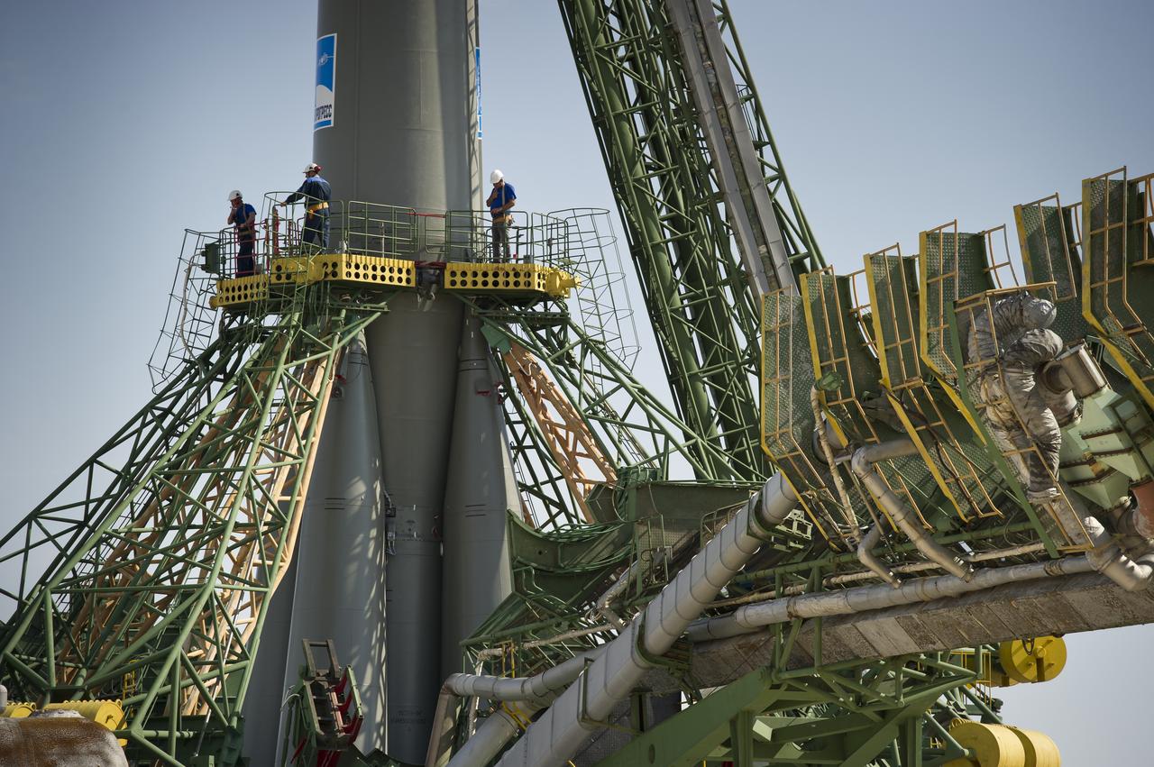 Launch pad engineers at the Baikonur Cosmodrome in Kazakhstan are dwarfed by the large gantry mechanisms at the base of the Soyuz TMA-02M rocket following its rollout to the pad on Sunday, June 5, 2011.  The rocket is being prepared for launch June 8 to carry the crew of Expedition 28 to the International Space Station.  Photo Credit:  (NASA/Carla Cioffi)