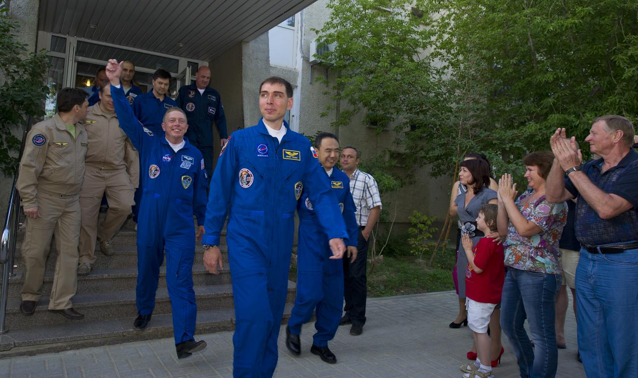 The crew of Expedition 28 depart the Cosmonaut Hotel depart the Cosmonaut Hotel on the evening before their Soyuz launch to the International Space Station Tuesday, June 7, 2011 in Baikonur, Kazakhstan.  Leading the way is Expedition 28 Soyuz Commander Sergei Volkov, followed by Expedition 28 Flight Engineer Mike Fossum, left, and JAXA Flight Engineer Satoshi Furukawa.  Photo Credit: (NASA/Carla Cioffi)