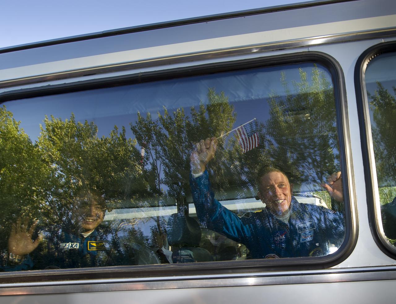Expedition 28 Flight Engineer and NASA astronaut Mike Fossum, right, and JAXA (Japanese Aerospace Exploration Agency) astronaut Satoshi Furukawa wave farewell to well wishers as they depart the Cosmonaut Hotel on the evening before his Soyuz launch to the International Space Station on Tuesday, June 7, 2011 in Baikonur, Kazakhstan  Photo Credit:  (NASA/Carla Cioffi)