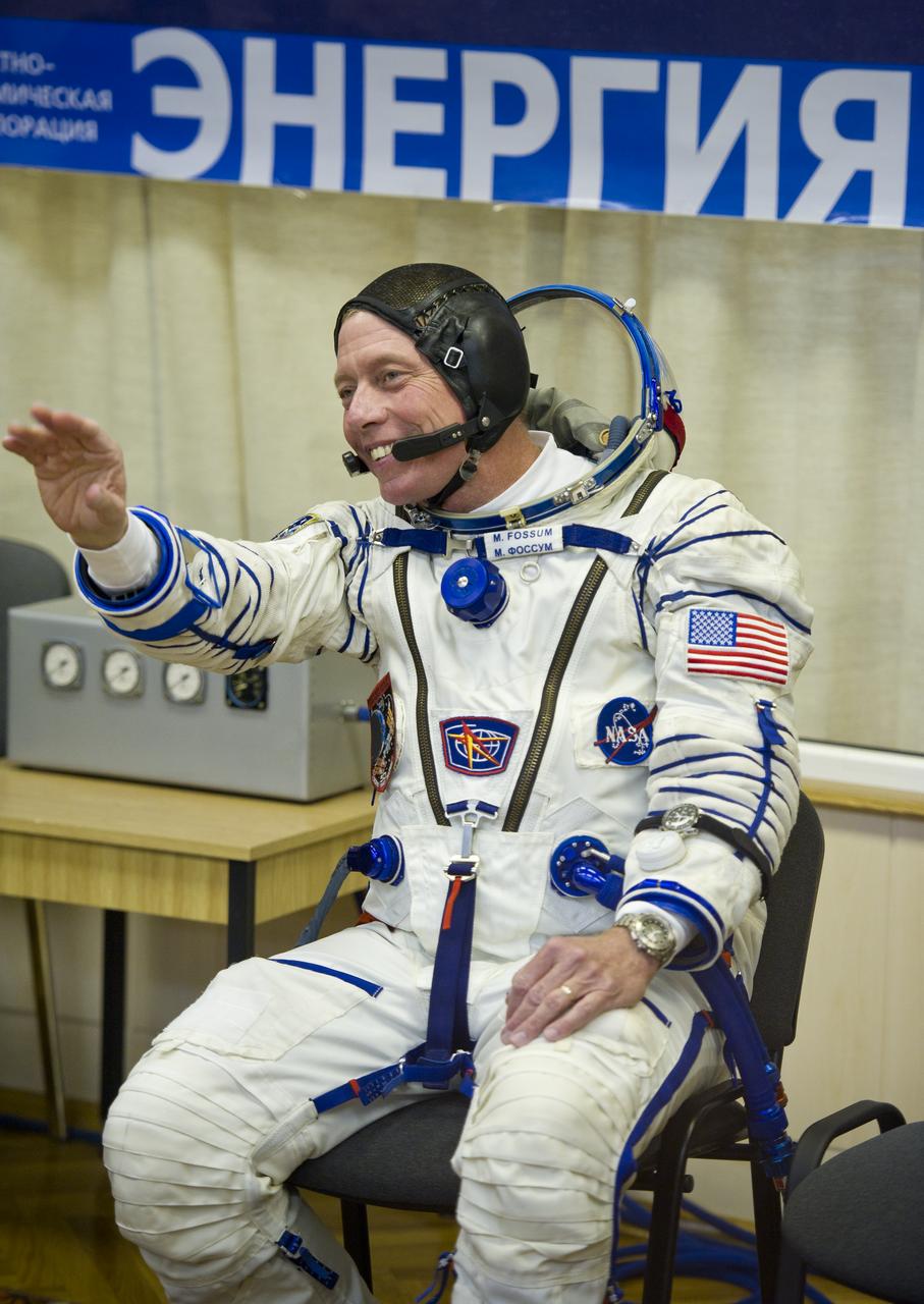 NASA astronaut and Expedition 28 Flight Engineer Mike Fossum waves to friends and family while he waits to have his Russian Sokol suit pressure checked in preparation for his launch onboard the Soyuz TMA-02M on Tuesday, June 7, 2011 at the Baikonur Cosmodrome in Kazakhstan.  The Soyuz spacecraft will carry Expedition 28 Soyuz Commander Sergei Volkov, JAXA (Japanese Aerospace Exploration Agency) Flight Engineer Satoshi Furukawa and Fossum to the International Space Station.  Photo Credit:  (NASA/Carla Cioffi)
