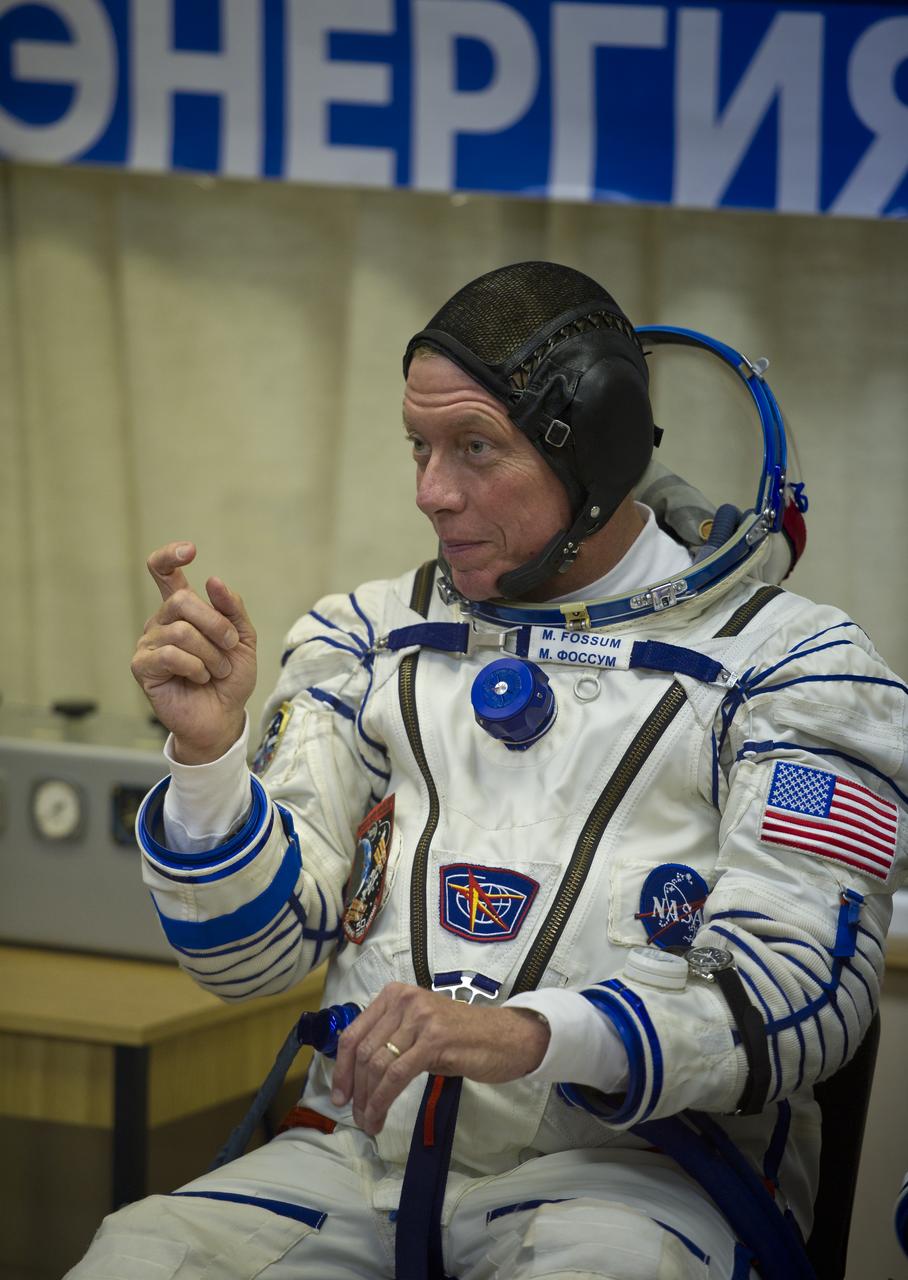 NASA astronaut and Expedition 28 Flight Engineer Mike Fossum motions to friends and family while he waits to have his Russian Sokol suit pressure checked in preparation for his launch onboard the Soyuz TMA-02M on Tuesday, June 7, 2011 at the Baikonur Cosmodrome in Kazakhstan.  The Soyuz spacecraft will carry Expedition 28 Soyuz Commander Sergei Volkov, JAXA (Japanese Aerospace Exploration Agency) Flight Engineer Satoshi Furukawa and Fossum to the International Space Station.  Photo Credit:  (NASA/Carla Cioffi)