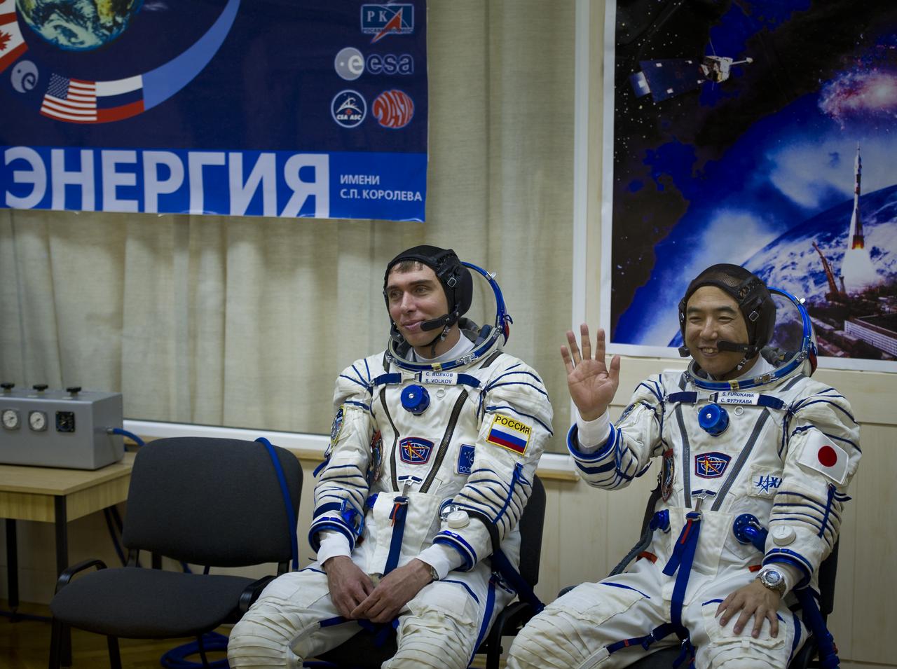 JAXA (Japanese Aerospace Exploration Agency) astronaut and Expedition 28 Flight Engineer Satoshi Furukawa, right, waves to friends and family, while Soyuz Commander Sergei Volkov looks on at the Baikonur Cosmodrome in Kazakhstan, Tuesday, June 7, 2011.  The crew of Expedition 28 will launch onboard their Soyuz TMA-02M on the morning of June 8 to the International Space Station.  Photo Credit:  (NASA/Carla Cioffi)