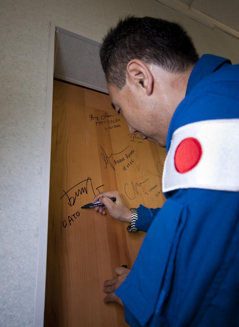 Expedition 28 JAXA (Japanase Aerospace Exploration Agency) astronaut and Flight Engineer Satoshi Furukawa performs the traditional door signing Tuesday, June 7, 2011 at the Cosmonaut Hotel in Baikonur, Kazakhstan. Furukawa was launched onboard the Soyuz rocket the following morning with Expedition 28 Soyuz Commander Sergei Volkov and NASA Flight Engineer Mike Fossum on a mission to the International Space Station (ISS).  Photo Credit: (NASA/Victor Zelentsov)