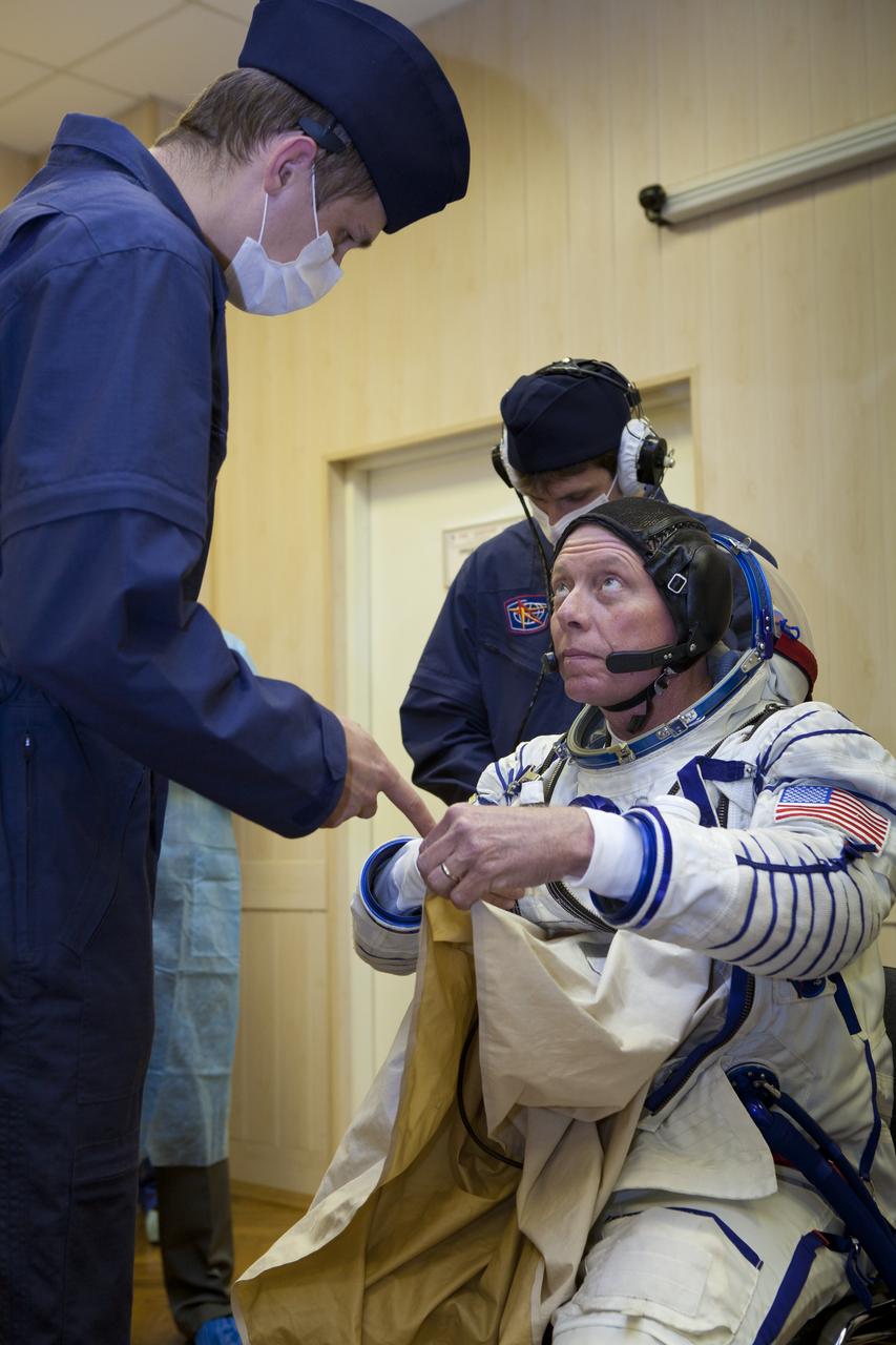 Expedition 28 NASA Flight Engineer Mike Fossum has his Russian Sokol suit prepared for launch by a technician at the Baikonur Cosmodrome in Baikonur, Kazakhstan, Tuesday, June 7, 2011.  Fossum and fellow Expedition 28 crew members Soyuz Commander Sergei Volkov and JAXA (Japanase Aerospace Exploration Agency) Flight Engineer Satoshi Furukawa launched in their Soyuz TMA-02M rocket from the Baikonur Cosmodrome in Kazakhstan the following morning on June 8th. Photo Credit: (NASA/Roscosmos/Andrey Shelepin)