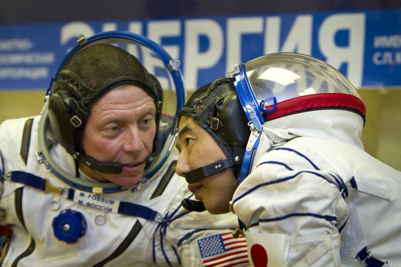 Expedition 28 NASA Flight Engineer, left, and Expedition 28 JAXA (Japan Aerospace Exploration Agency) Flight Engineer Satoshi Furukawa share a few words during preparation activities for their launch to the International Space Station, Tuesday, June June 7, 2011 at the Baikonur Cosmodrome in Kazakhstan.  Photo Credit: (NASA/Roscosmos/Andrey Shelepin)