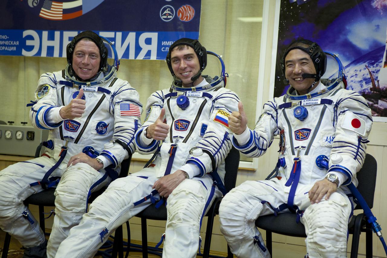 The crew of Expedition 28 gives the thumbs after having their Russian Sokol suits prepared for launch at the Baikonur Cosmodrome Tuesday, June 7, 2011 in Kazakhstan.  Pictured from left are NASA Flight Engineer Mike Fossum, Soyuz Commander Sergei Volkov and JAXA (Japan Aerospace Exploration Agency)Flight Engineer Satoshi Furukawa.  Photo Credit: (NASA/Roscosmos/Andrey Shelepin)