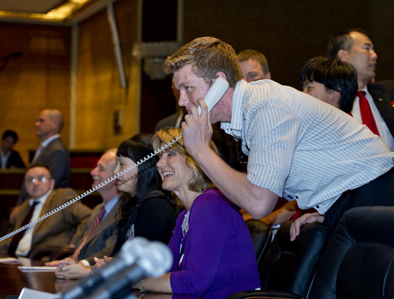 Mitchell Fossum, right, son of Expedition 28 NASA Flight Engineer Mike Fossum, is seen at Russian Mission Control in Korolev, Russia speaking to his father shortly after his arrival at the International Space Station on Friday, June 10, 2011. Photo Credit: (NASA/Carla Cioffi)