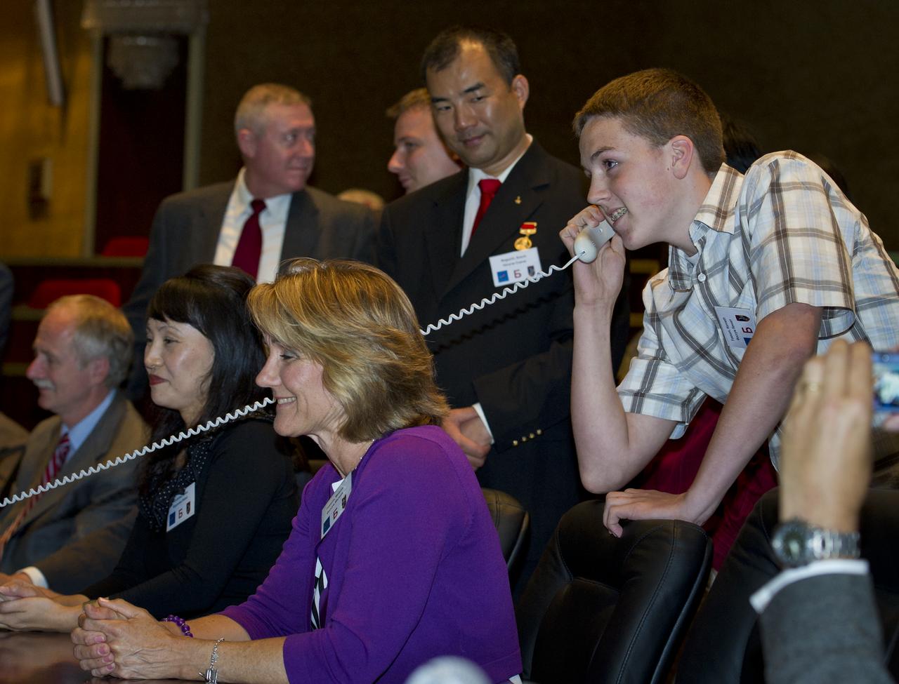 Kenny Fossum, right, youngest son of Expedition 28 NASA Flight Engineer Mike Fossum, is seen at Russian Mission Control in Korolev, Russia speaking to his father shortly after his arrival at the International Space Station on Friday, June 10, 2011. Photo Credit: (NASA/Carla Cioffi)