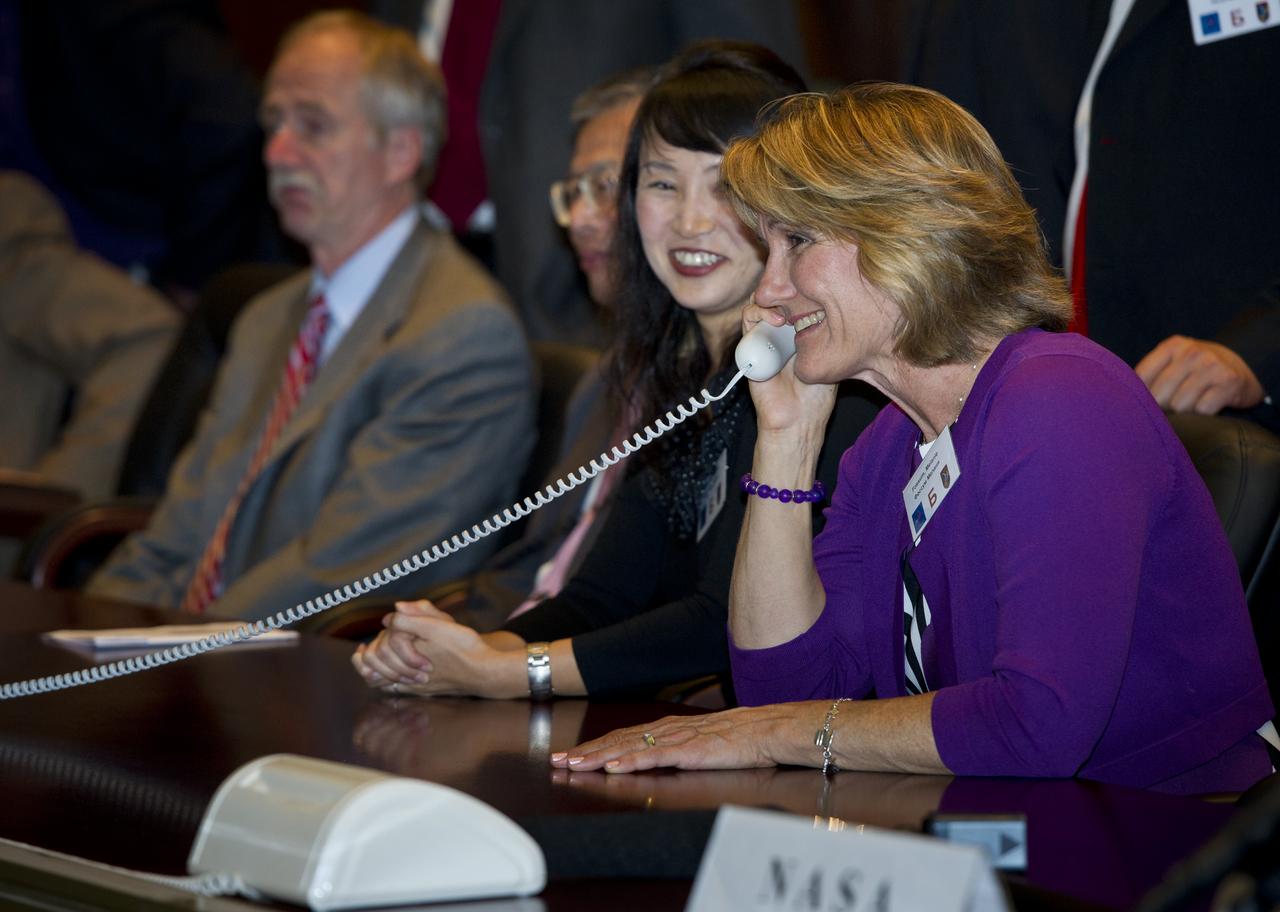 Melanie Fossum, right, wife of Expedition 28 NASA Flight Engineer Mike Fossum, is seen at Russian Mission Control in Korolev, Russia speaking to her husband shortly after his arrival at the International Space Station on Friday, June 10, 2011. Photo Credit: (NASA/Carla Cioffi)