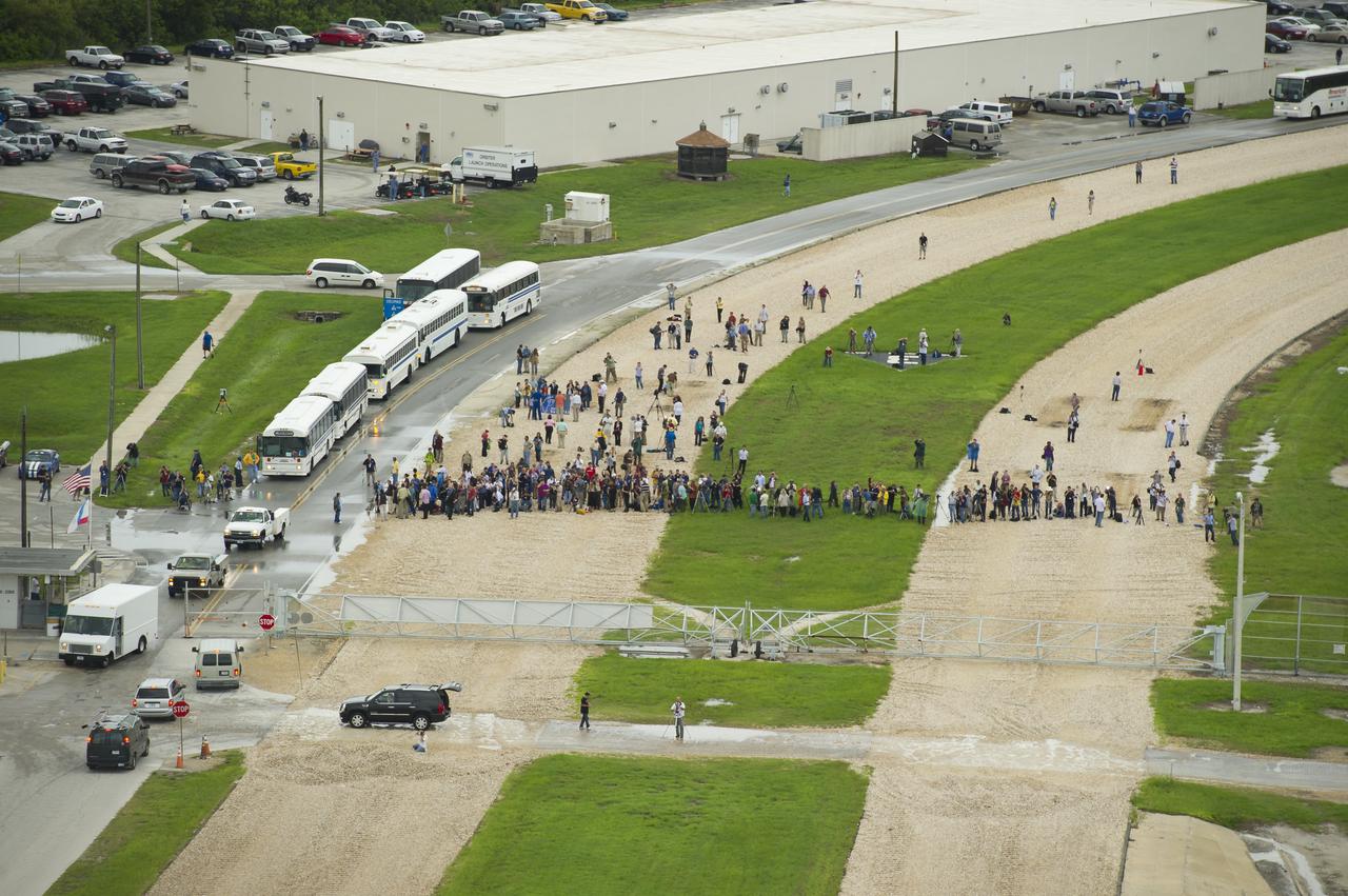 Press and guest watch from outside the perimeter of Launch Pad 39a as the space shuttle Atlantis is revealed during the rotating service structure (RSS) is rolled back on Thursday, July 7, 2011 at the NASA Kennedy Space Center in Cape Canaveral, Fla.  Atlantis is set to liftoff Friday, July 8, on the final flight of the shuttle program, STS-135, a 12-day mission to the International Space Station.  Photo Credit: (NASA/Bill Ingalls)