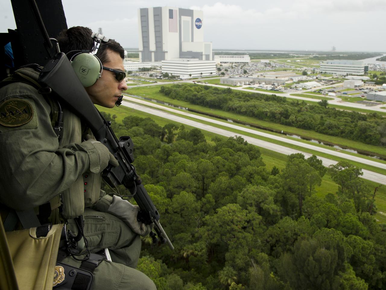 Warren Hinson, a NASA Emergency Response Team (ERT) member, keeps an eye out while flying near the Vehicle Assembly Building (VAB) prior to the launch of space shuttle Atlantis, STS-135, Friday, July 8, 2011, at Kennedy Space Center in Cape Canaveral, Fla. The launch of Atlantis, is the final flight of the shuttle program, a 12-day mission to the International Space Station. Photo Credit: (NASA/Bill Ingalls)