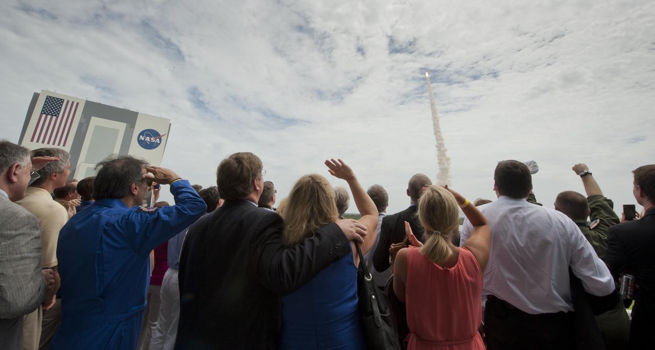 Guests look on from the terrace of Operations Support Building II as space shuttle Atlantis launches from launch pad 39A on the STS-135 mission Friday, July 8, 2011, at Kennedy Space Center in Cape Canaveral, Fla. Atlantis and its crew will deliver to the International Space Station the Raffaello multipurpose logistics module containing supplies and spare parts for the space station. Photo Credit: (NASA/Carla Cioffi)