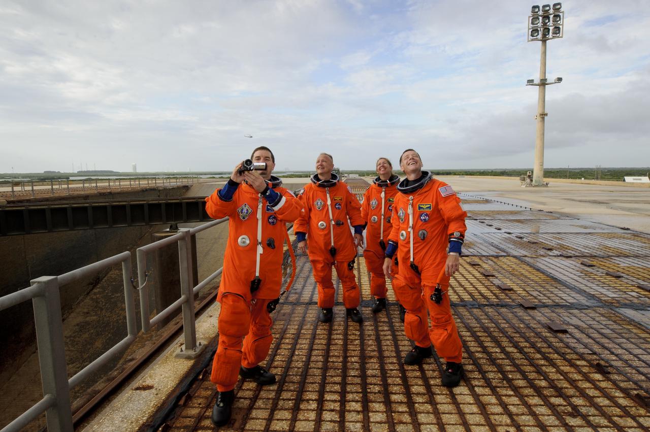 The STS-135 mission specialist Rex Walheim, left, Doug Hurley, pilot; second from left, Sandy Magnus, mission specialist; and Chris Ferguson, commander, right, stop and take a moment to look up at the space shuttle Atlantis prior to boarding at launch pad 39A, Friday, July 8, 2011 at the NASA Kennedy Space Center in Cape Canaveral, Fla. The launch of Atlantis, STS-135, is the final flight of the shuttle program, a 12-day mission to the International Space Station. Photo Credit: (NASA/Jerry Ross)