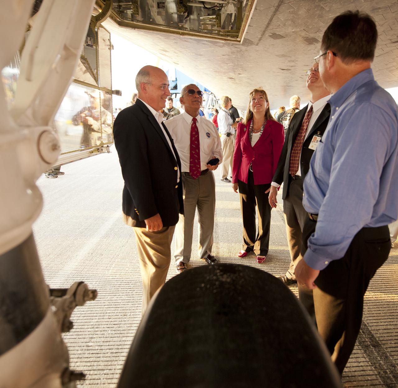 NASA International Space Station Program Office Manager Michael Suffredini, left, NASA Administrator Charles Bolden, second from left, Deputy Administrator Lori Garver, Manager, Space Shuttle Program Office John Shannon, third from left, and an unidentified colleague, talk under the space shuttle Atlantis at the Kennedy Space Center Shuttle Landing Facility (SLF) shortly after Atlantis (STS-135) landed early Thursday morning, July 21, 2011, in Cape Canaveral, Fla. Overall, Atlantis spent 307 days in space and traveled nearly 126 million miles during its 33 flights. Atlantis, the fourth orbiter built, launched on its first mission on Oct. 3, 1985. Photo Credit: (NASA/Bill Ingalls)