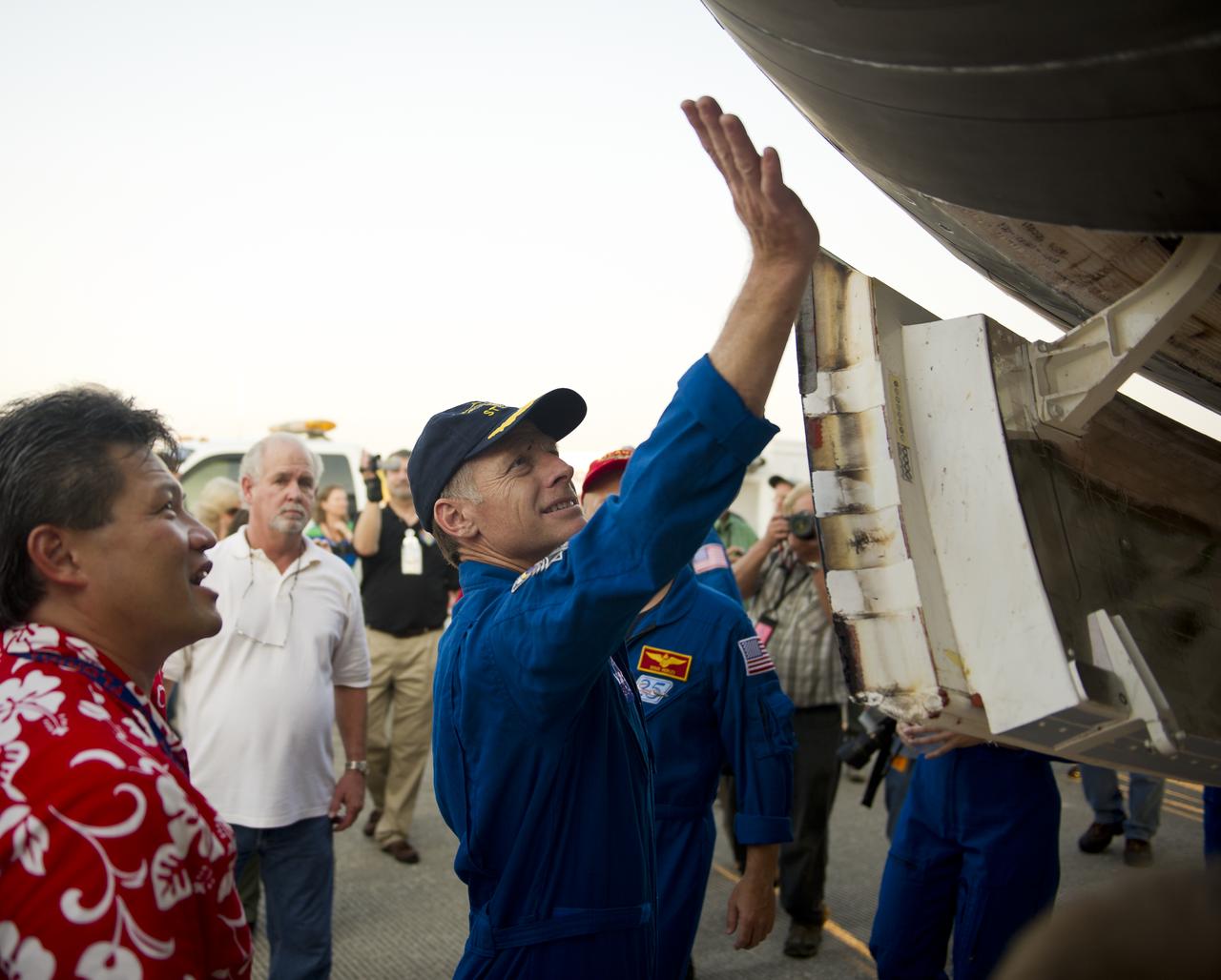 NASA Astronaut and STS-135 Commander Chris Ferguson walks underneath the space shuttle Atlantis shortly after he and the rest of the STS-135 crew landed at NASA's Kennedy Space Center Shuttle Landing Facility (SLF), completing a 13-day mission to the International Space Station (ISS) and the final flight of the Space Shuttle Program, early Thursday morning, July 21, 2011, in Cape Canaveral, Fla. Overall, Atlantis spent 307 days in space and traveled nearly 126 million miles during its 33 flights. Atlantis, the fourth orbiter built, launched on its first mission on Oct. 3, 1985. Photo Credit: (NASA/Bill Ingalls)