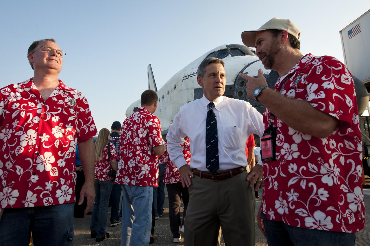 NASA Kennedy Space center Director Robert Cabana talks with members of the shuttle tile team which are wearing flowered shirts together at the Shuttle Landing Facility (SLF) runway at NASA Kennedy Space Center shortly after the space shuttle Atlantis (STS-135) landed, completing its 13-day mission to the International Space Station (ISS) and the final flight of the Space Shuttle Program, early Thursday morning, July 21, 2011, in Cape Canaveral, Fla. Overall, Atlantis spent 307 days in space and traveled nearly 126 million miles during its 33 flights. Atlantis, the fourth orbiter built, launched on its first mission on Oct. 3, 1985. Photo Credit: (NASA/Bill Ingalls)