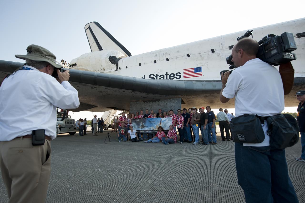 NASA and contractor personnel are photographed under the wing of the space shuttle Atlantis at the Kennedy Space Center Shuttle Landing Facility (SLF) shortly after Atlantis (STS-135) landed early Thursday morning, July 21, 2011, in Cape Canaveral, Fla. Overall, Atlantis spent 307 days in space and traveled nearly 126 million miles during its 33 flights. Atlantis, the fourth orbiter built, launched on its first mission on Oct. 3, 1985. Photo Credit: (NASA/Bill Ingalls)