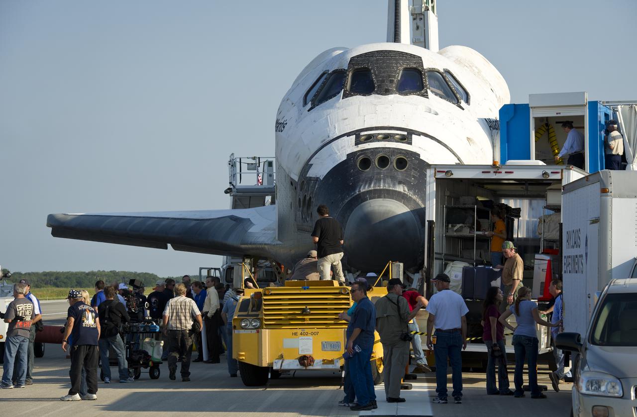 NASA and contractor personnel work on the space shuttle Atlantis at the Kennedy Space Center Shuttle Landing Facility (SLF) shortly after Atlantis (STS-135) landed early Thursday morning, July 21, 2011, in Cape Canaveral, Fla. Overall, Atlantis spent 307 days in space and traveled nearly 126 million miles during its 33 flights. Atlantis, the fourth orbiter built, launched on its first mission on Oct. 3, 1985. Photo Credit: (NASA/Bill Ingalls)