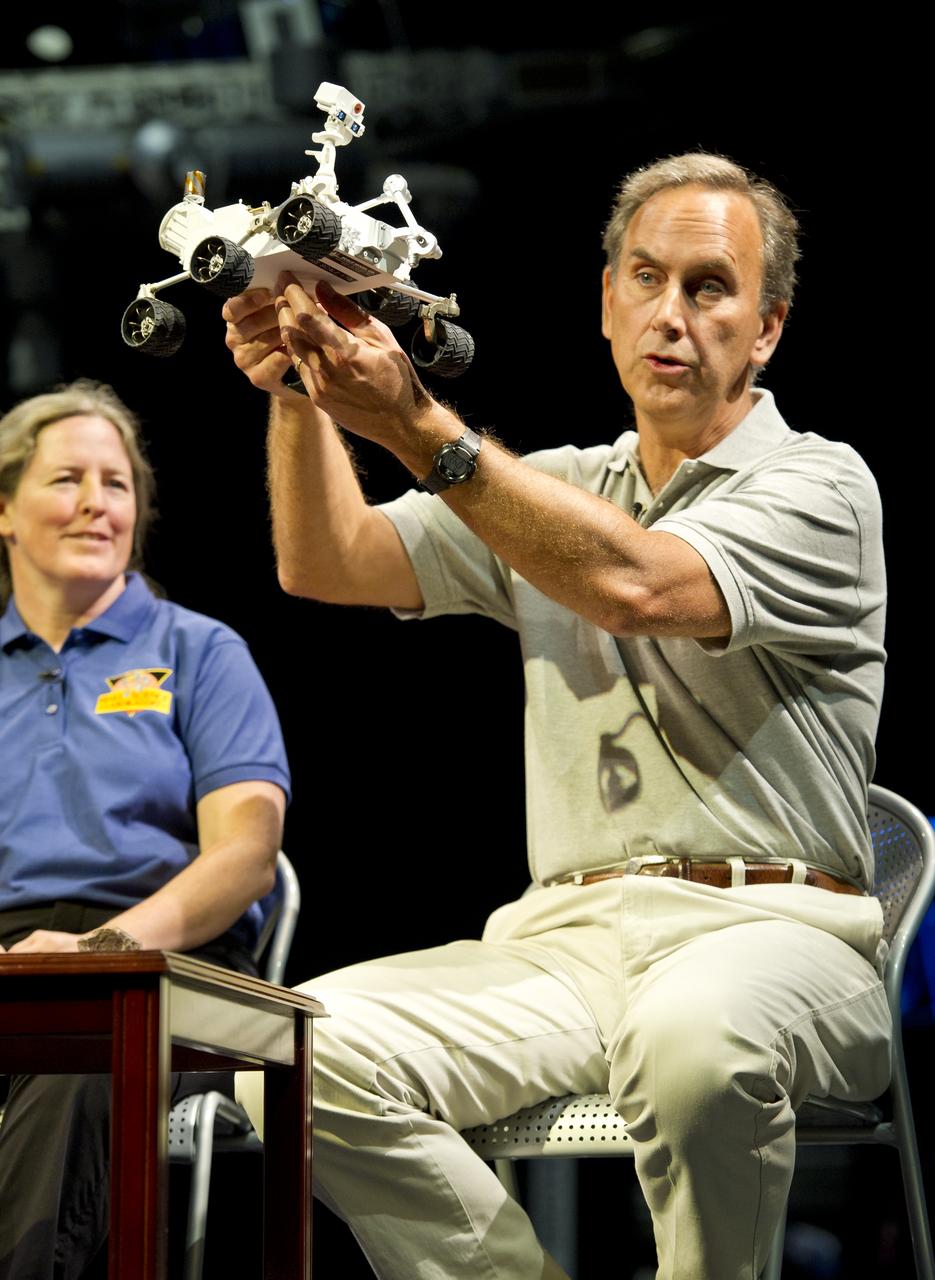 John Grotzinger, Mars Science Laboratory (MSL) project scientist, Jet Propulsion Lab (JPL), Pasadena, Calif., holds up a model of the MSL, or Curiosity, at a press conference at the Smithsonian's National Air and Space Museum on Friday, July 22, 2011 in Washington. The MSL is scheduled to launch late this year from NASA's Kennedy Space Center in Florida and land in August 2012. Curiosity is twice as long and more than five times as heavy as previous Mars rovers. The rover will study whether the landing region at Gale crater had favorable environmental conditions for supporting microbial life and for preserving clues about whether life ever existed. Photo Credit: (NASA/Carla Cioffi)