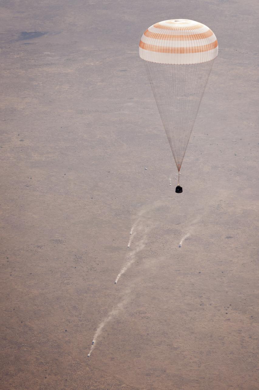 Ground support vehicles can be seen chasing the Soyuz TMA-21 spacecraft as it lands with Expedition 28 Commander Andrey Borisenko, and Flight Engineers Ron Garan, and Alexander Samokutyaev in a remote area outside of the town of Zhezkazgan, Kazakhstan, on Friday, Sept. 16, 2011. NASA Astronaut Garan, Russian Cosmonauts Borisenko and Samokutyaev are returning from more than five months onboard the International Space Station where they served as members of the Expedition 27 and 28 crews. Photo Credit: (NASA/Bill Ingalls)