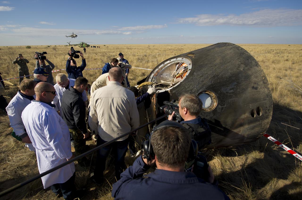 Russian support personnel work to help get crew members out of the Soyuz TMA-21 spacecraft shortly after the capsule landed with Expedition 28 Commander Andrey Borisenko, and Flight Engineers Ron Garan, and Alexander Samokutyaev in a remote area outside of the town of Zhezkazgan, Kazakhstan, on Friday, Sept. 16, 2011. NASA Astronaut Garan, Russian Cosmonauts Borisenko and Samokutyaev are returning from more than five months onboard the International Space Station where they served as members of the Expedition 27 and 28 crews. Photo Credit: (NASA/Bill Ingalls)