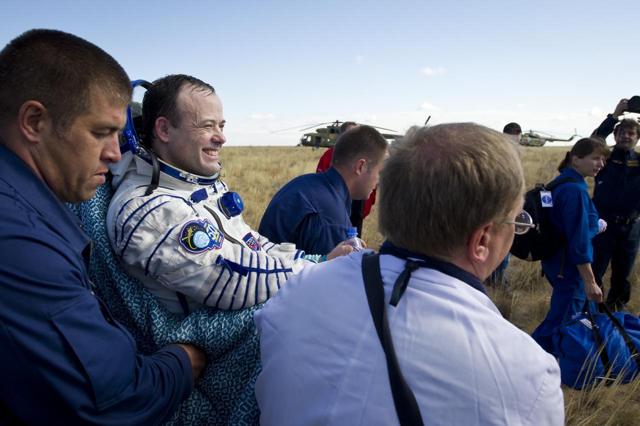 Expedition 28 Flight Engineer Ron Garan smiles as he is carried in a chair to the medical tent shortly after he and Expedition 28 Commander Andrey Borisenko, and Flight Engineer Alexander Samokutyaev landed in their Soyuz TMA-21 Soyuz Capsule in a remote area outside the town of Zhezkazgan, Kazakhstan, on Friday, Sept. 16, 2011. NASA Astronaut Garan, Russian Cosmonauts Borisenko and Samokutyaev are returning from more than five months onboard the International Space Station where they served as members of the Expedition 27 and 28 crews. Photo Credit: (NASA/Bill Ingalls)